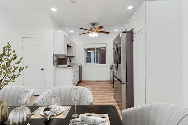 kitchen featuring ceiling fan, light hardwood / wood-style floors, white cabinetry, and appliances with stainless steel finishes