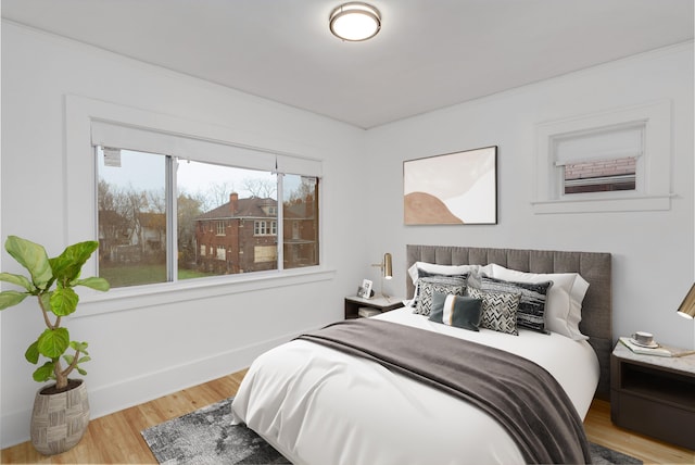 bedroom with light hardwood / wood-style flooring and ornamental molding