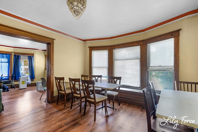 dining room with ornamental molding and dark wood-type flooring