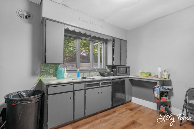 kitchen with light wood-type flooring, black dishwasher, gray cabinets, and sink