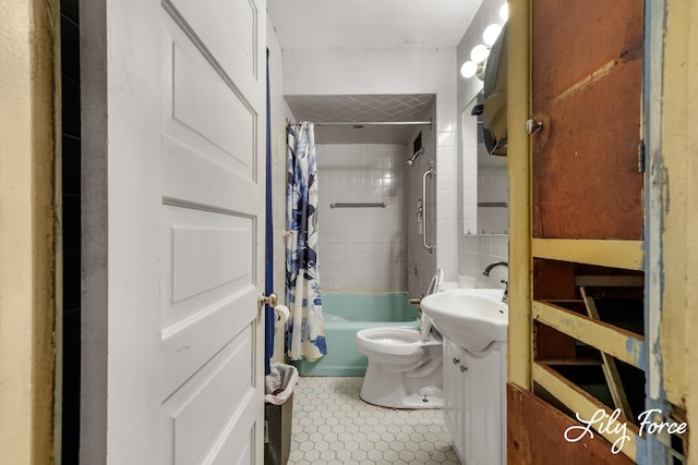 full bathroom with tile patterned floors, toilet, shower / bath combo with shower curtain, vanity, and tile walls