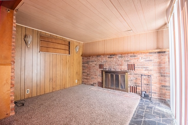 unfurnished living room with dark colored carpet, wood walls, and wood ceiling