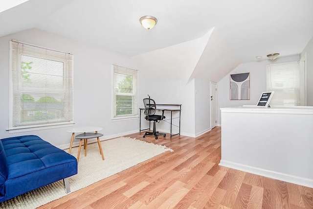 living area with plenty of natural light, light hardwood / wood-style floors, and lofted ceiling