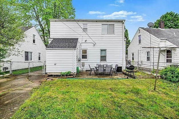 rear view of property with a patio area and a yard