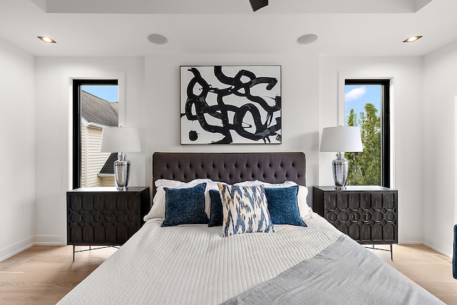 bedroom with light hardwood / wood-style flooring and multiple windows