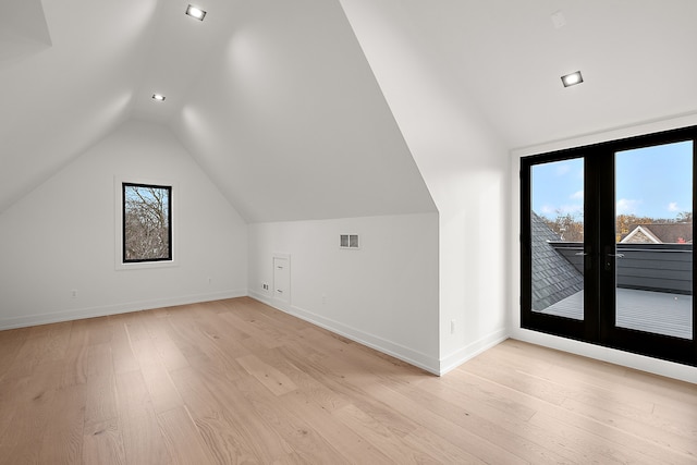 additional living space featuring light hardwood / wood-style floors and lofted ceiling