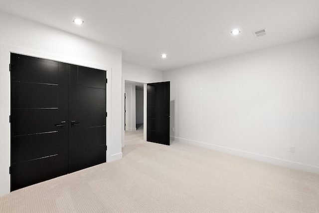 bedroom with light carpet and a closet