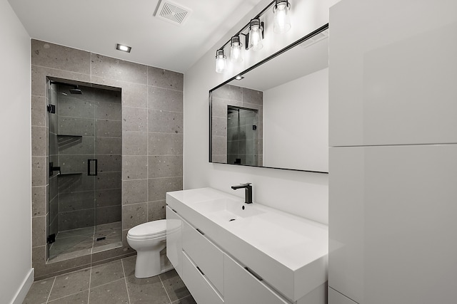 bathroom with vanity, toilet, a shower with door, and tile walls