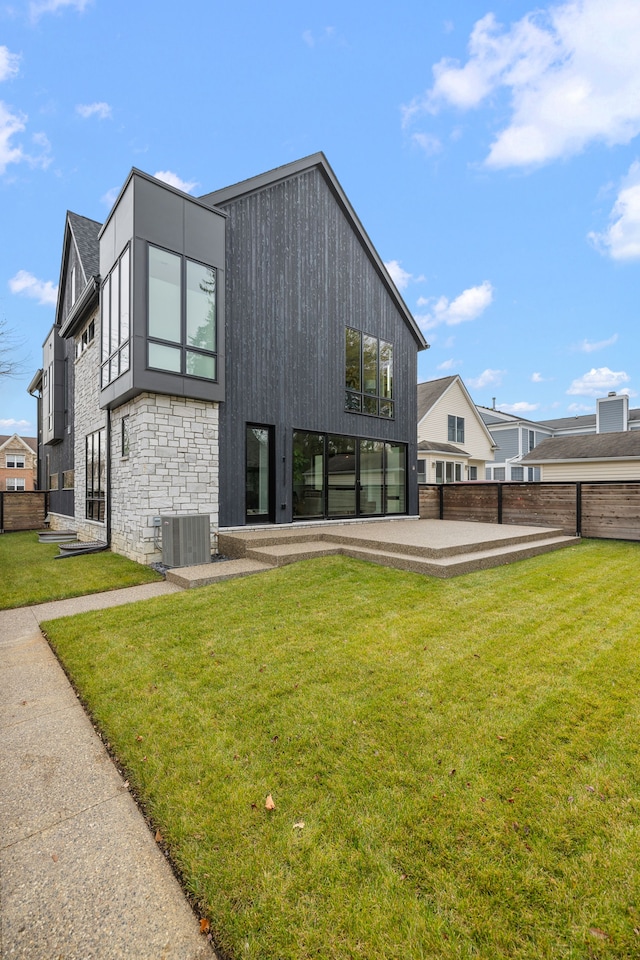 back of property with a lawn, cooling unit, and a patio