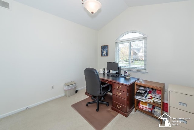 carpeted home office with vaulted ceiling