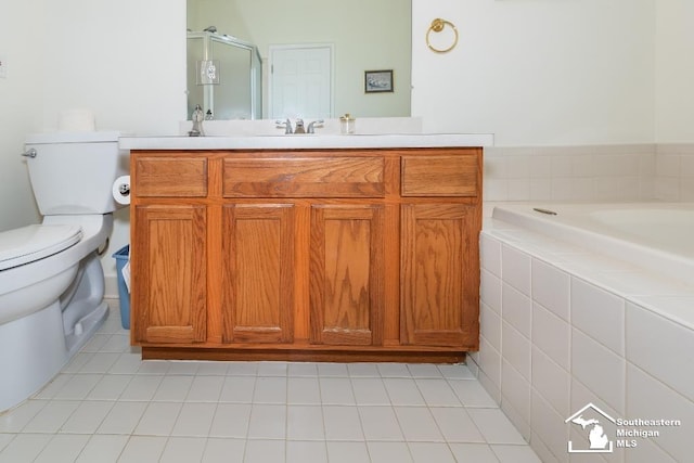 bathroom with tile patterned flooring, tiled bath, vanity, and toilet