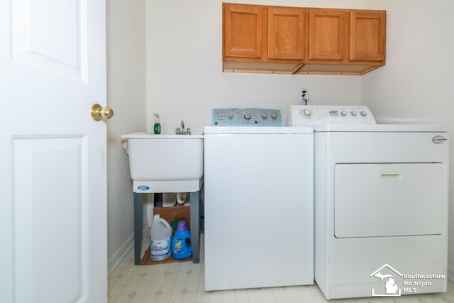 laundry room with washer and dryer, cabinets, and sink