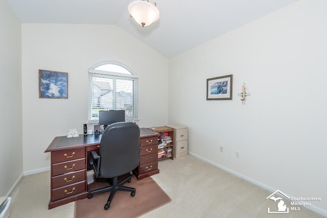 carpeted home office featuring vaulted ceiling