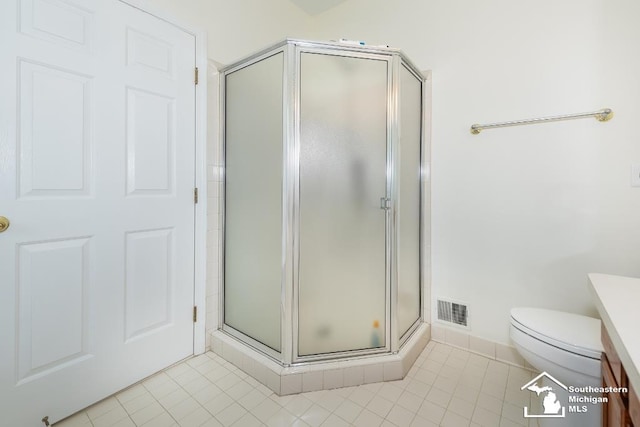 bathroom with toilet, an enclosed shower, vanity, and tile patterned floors