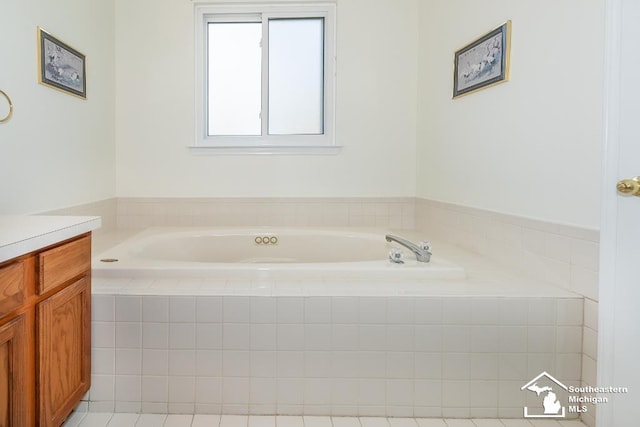 bathroom featuring tiled bath and vanity