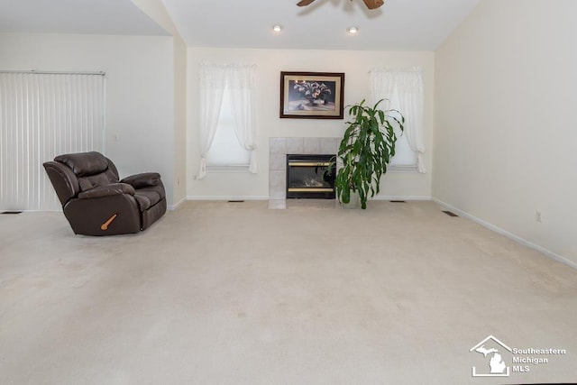 sitting room featuring a fireplace, light carpet, and ceiling fan