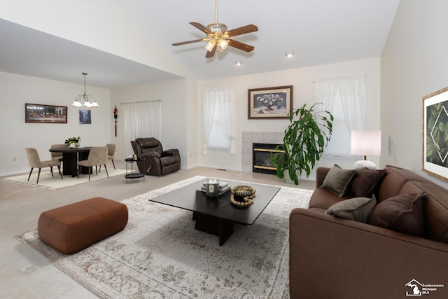 carpeted living room featuring ceiling fan with notable chandelier and a fireplace