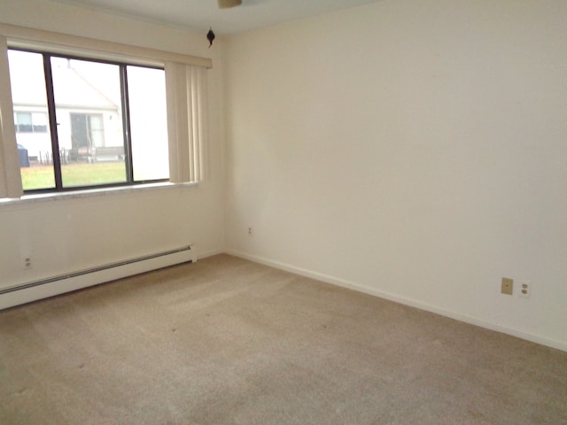 carpeted empty room featuring baseboard heating