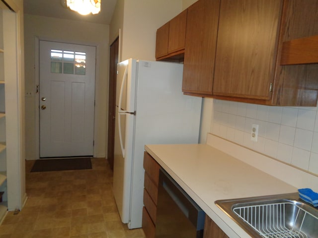 kitchen with backsplash, dishwasher, and white refrigerator