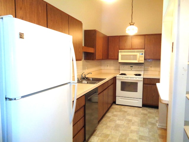 kitchen featuring backsplash, decorative light fixtures, white appliances, and sink