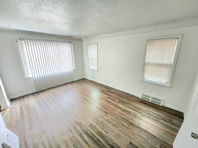 spare room with hardwood / wood-style floors and a textured ceiling