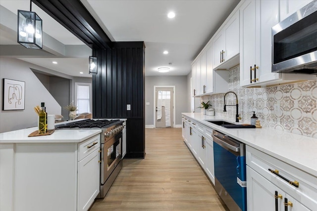 kitchen with sink, white cabinetry, and stainless steel appliances