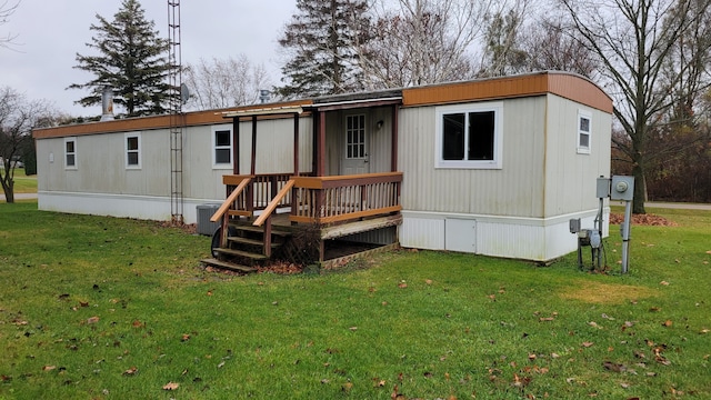 back of property with a lawn and central AC