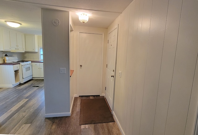 interior space with white cabinetry, gas range gas stove, and dark wood-type flooring