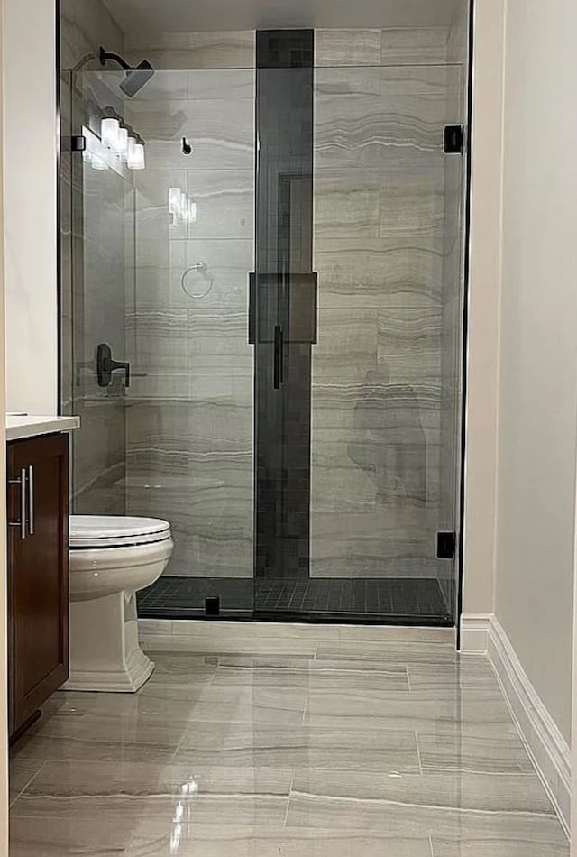 bathroom with walk in shower, vanity, and toilet