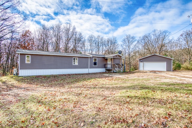 view of front of home featuring a garage, an outdoor structure, and a front yard