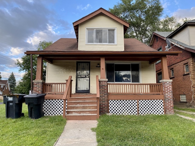 view of front of house with covered porch and a front lawn