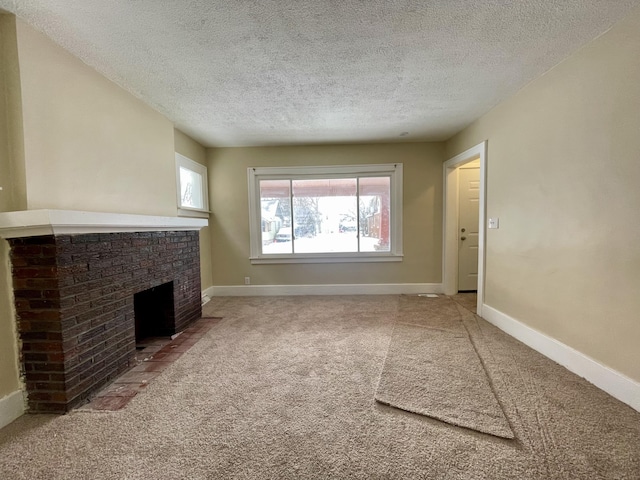 unfurnished living room with carpet, a textured ceiling, and a brick fireplace