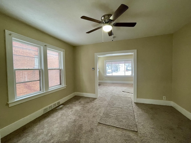 carpeted spare room featuring ceiling fan