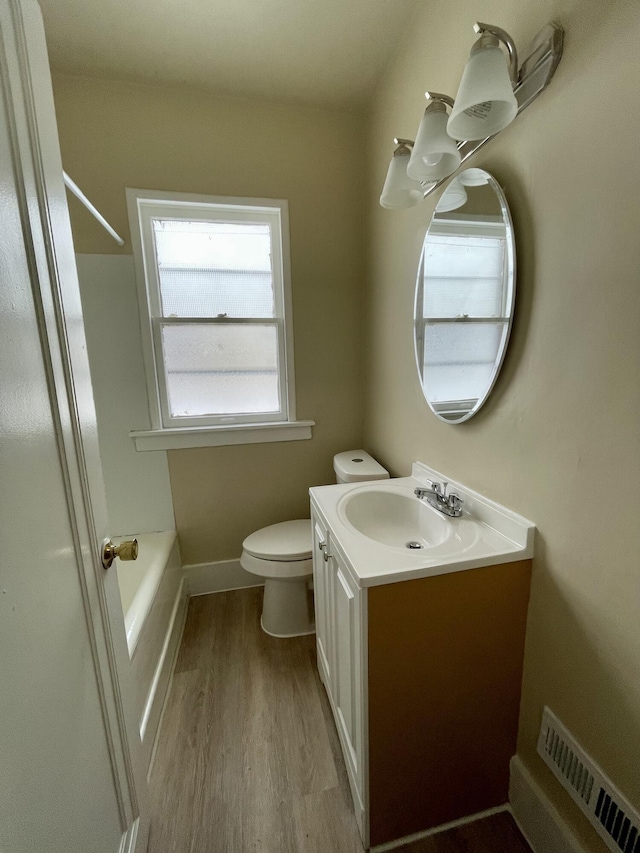 full bathroom with hardwood / wood-style floors, vanity, shower with separate bathtub, and toilet