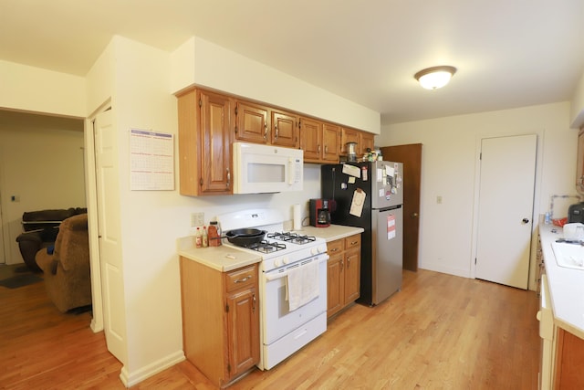 kitchen featuring light hardwood / wood-style floors and white appliances