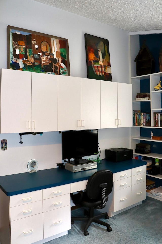 carpeted office with a textured ceiling