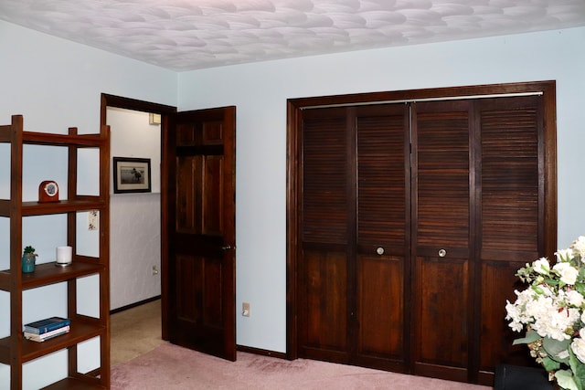 unfurnished bedroom with light colored carpet and a textured ceiling