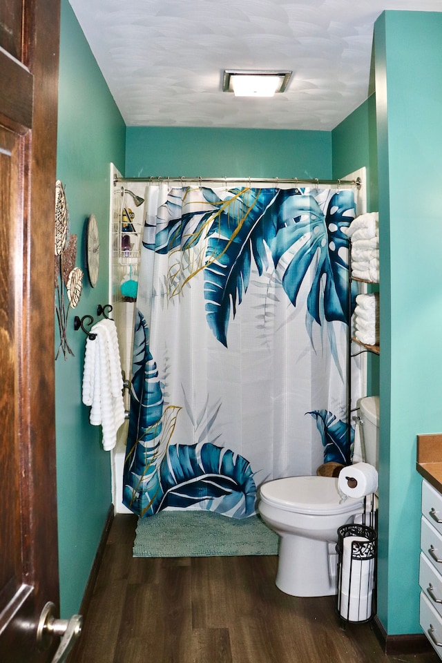 bathroom with a shower with curtain, hardwood / wood-style floors, vanity, and toilet