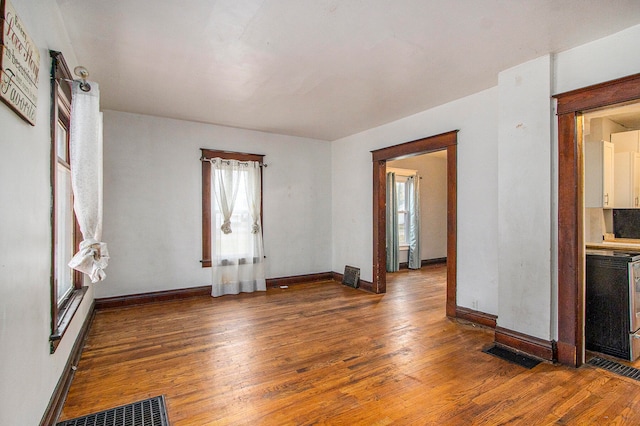 empty room with a wealth of natural light and dark wood-type flooring