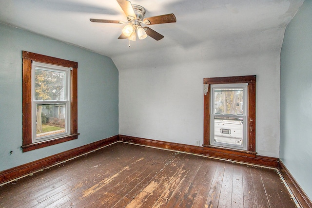 empty room with dark hardwood / wood-style floors, ceiling fan, and vaulted ceiling