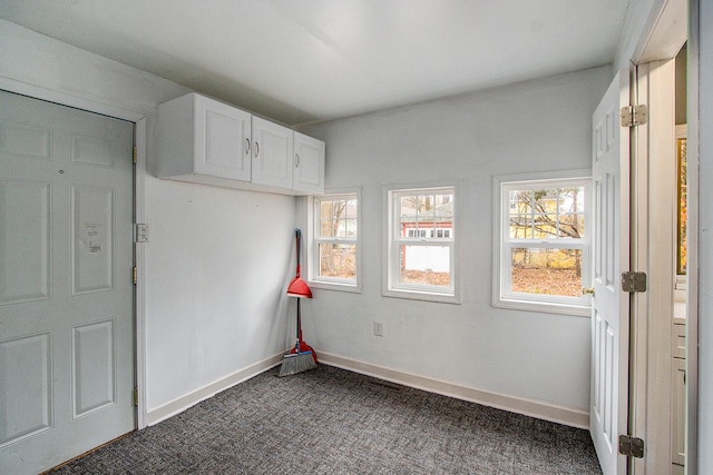 unfurnished room with dark carpet