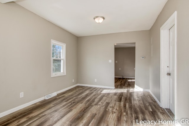 unfurnished room featuring dark wood-type flooring