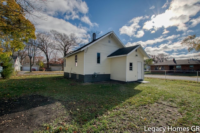 rear view of house featuring a lawn