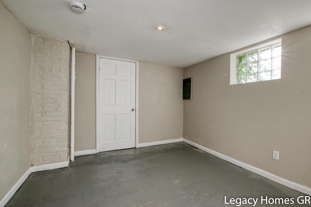 basement with electric panel and a textured ceiling