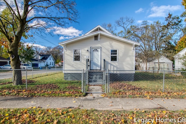 bungalow-style home with a front yard