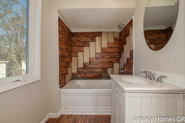 bathroom with hardwood / wood-style flooring, a bathtub, and vanity