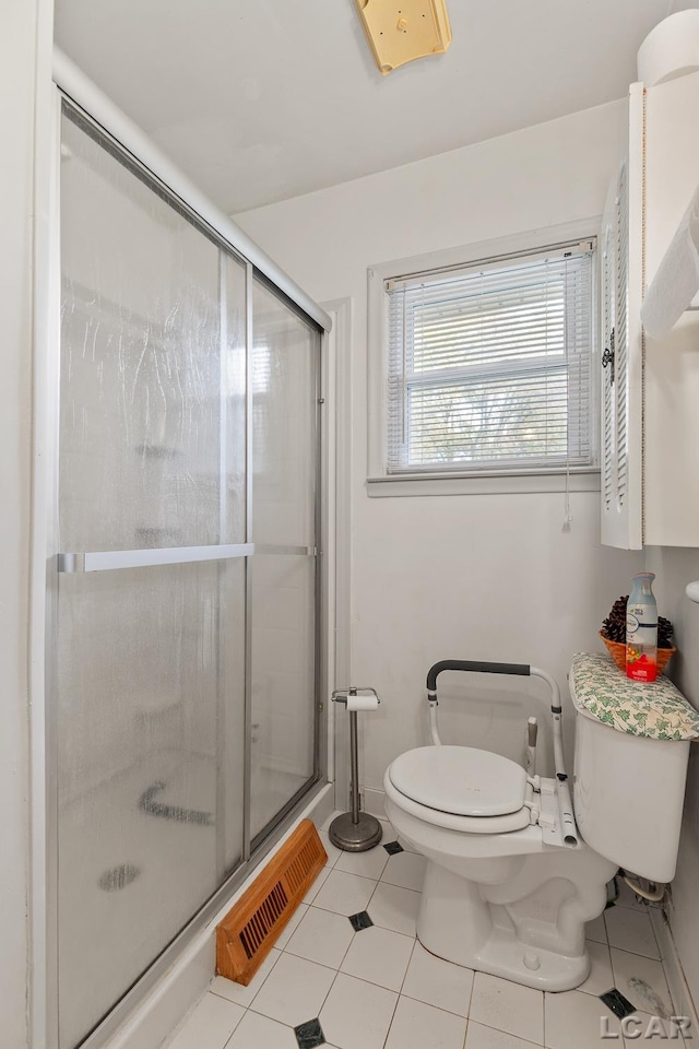 bathroom with tile patterned floors, an enclosed shower, and toilet