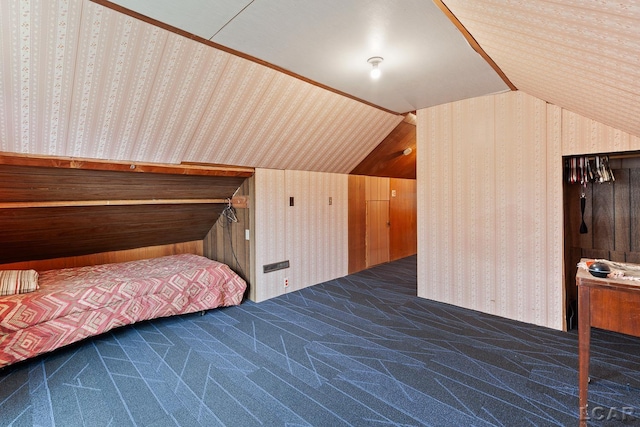 unfurnished bedroom featuring dark carpet and vaulted ceiling