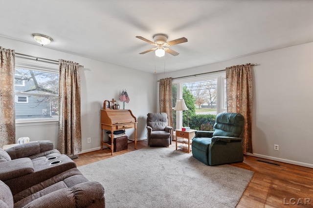 living area featuring light hardwood / wood-style floors and ceiling fan