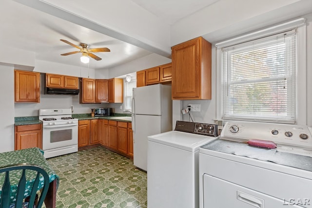 kitchen featuring ceiling fan, white appliances, sink, and washing machine and clothes dryer